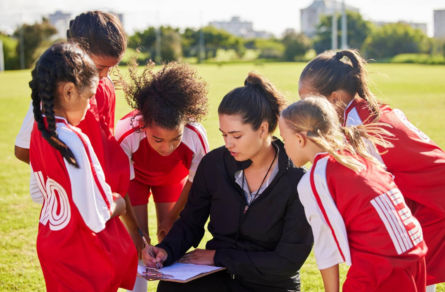 coach guiding youth soccer team during practice